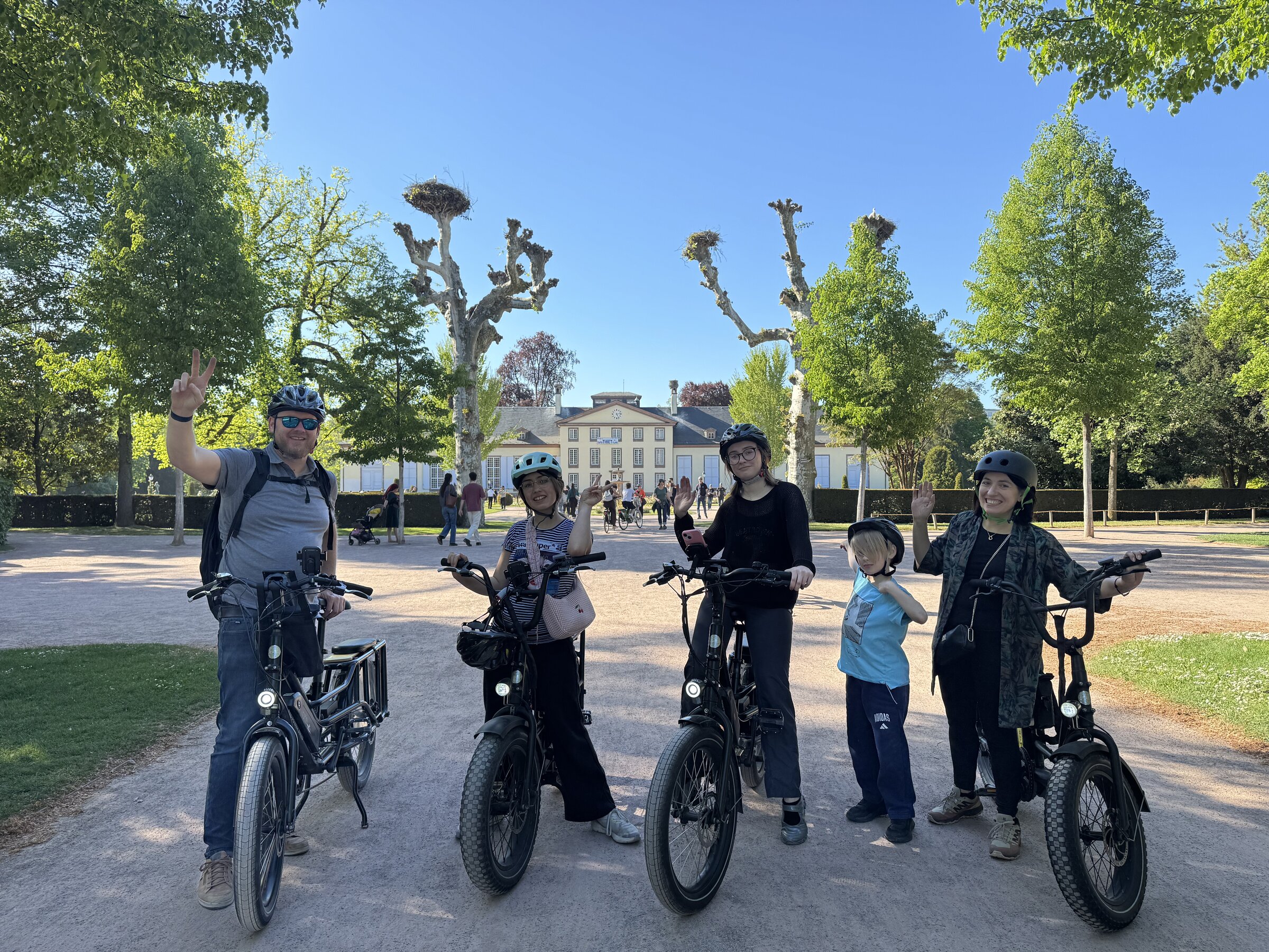Family on STRIM e-bikes in front of Pavillon Joséphine, Parc de l'Orangerie, Strasbourg